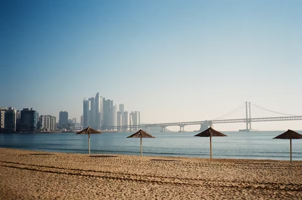 Haeundae Beach with parasols and Gwangandaegyo Bridge in the background, Busan, South Korea