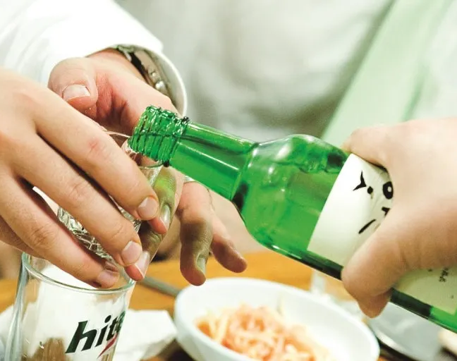 Pouring soju politely with two hands in Korea